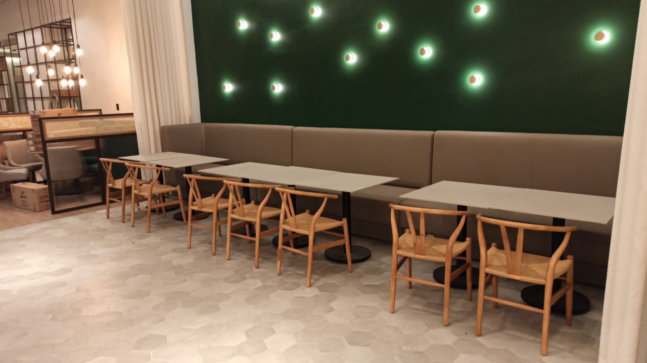 Banqueta e mesas com cadeiras wishbone
