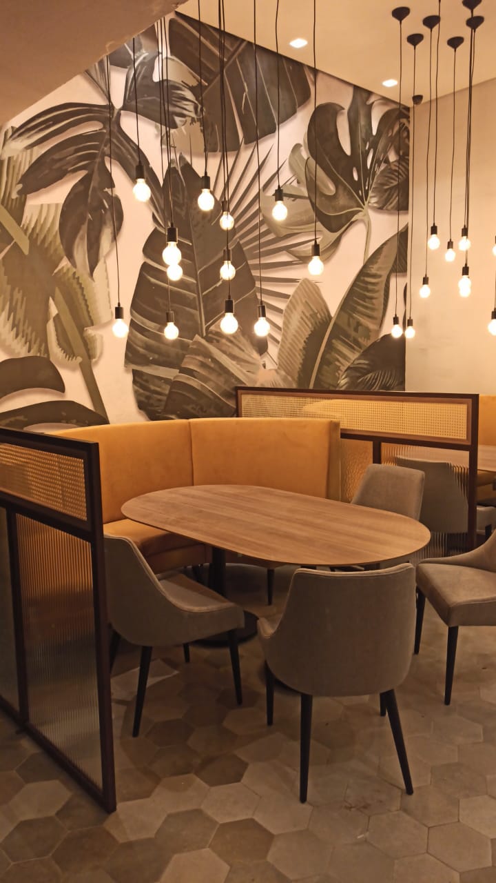 Booth amarelo com mural tropical
