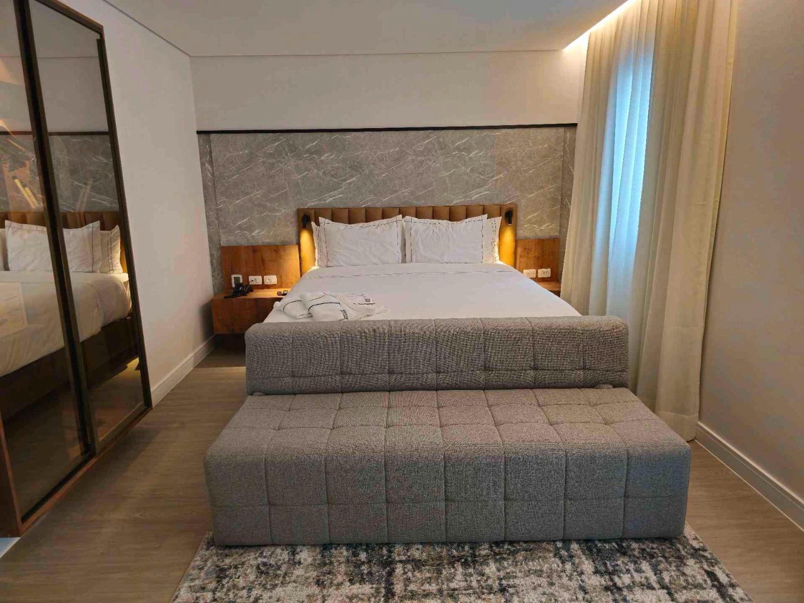 Quarto com banco estofado na frente da cama